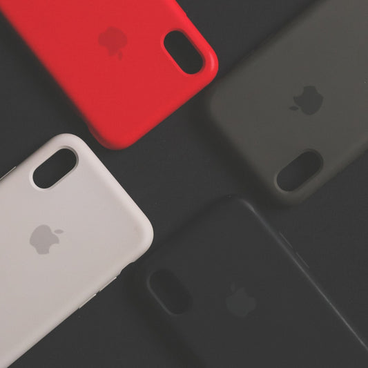 Four iphone cases in different colors on black background